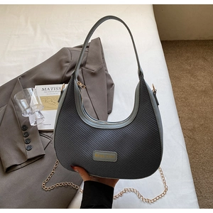 Détail du sac hobo tissé bleu avec étiquette Miss mini en cuir et chaîne dorée