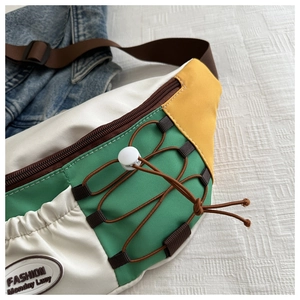 Dettaglio borsa a tracolla in nylon color-block con coulisse e toppa alla moda