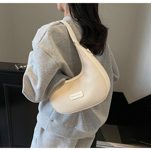 Détail du sac hobo tissé crème avec bandoulière en cuir et étiquette Miss Mini