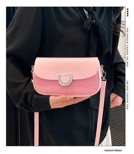 Detail of pink contrast flap bag showing textured fabric and silver D-buckle closure