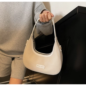 Détail du sac beige tissé en forme de croissant avec logo Miss mini et anse en cuir