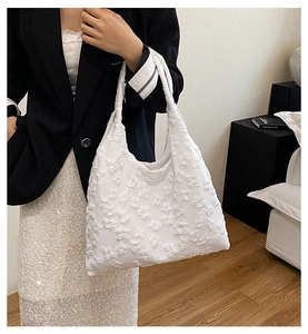 Dettaglio ravvicinato della trama jacquard floreale bianca di questa borsa hobo chic