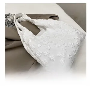 Close-up of the elegant white floral jacquard fabric and 3D flower texture on the tote bag