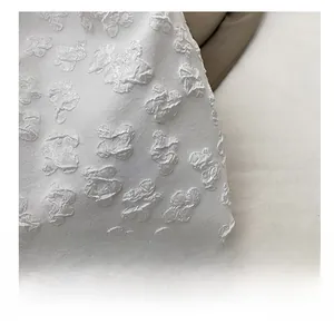 Detail view of 3D embossed floral pattern on white lace fabric for elegant tote bag