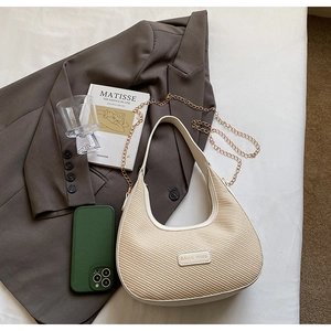 Détail du sac beige tissé avec bandoulière chaîne dorée et plaque logo Miss mini