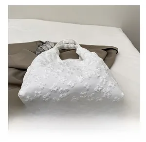 Detail showing white floral texture and durable bottom on a large canvas tote bag