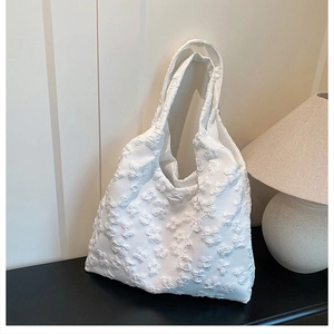 Detailed close-up of white floral lace tote bag with 3D butterfly embroidery texture