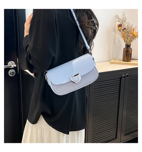 Detail of light blue crossbody bag with striped fabric and silver metal D-buckle