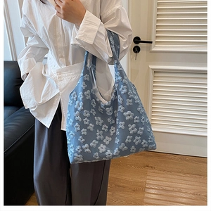 Detail of light blue floral lace tote bag with 3D embroidery and soft texture finish