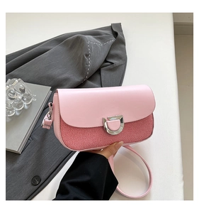 Close-up of pink leather and red fabric shoulder bag with silver D-shaped buckle