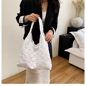 Detailed macro view of 3D white floral applique texture on a summer lace tote handbag