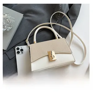 Close-up of beige crossbody bag with smartphone for size comparison on a blazer