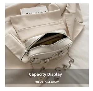 Detail showing white leather shoulder bag with silver chain and spacious inner compartment