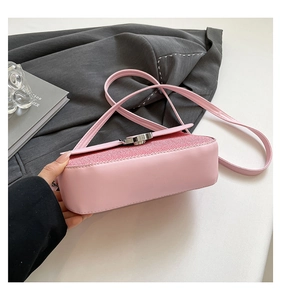 Detail of pink shoulder bag with glitter fabric flap and round silver buckle closure