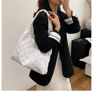 Detail of floral texture on white shoulder bag with 3D butterfly jacquard patterns