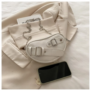 Gros plan d'un sac besace blanc en cuir avec boucles argentées et bandoulière en chaîne