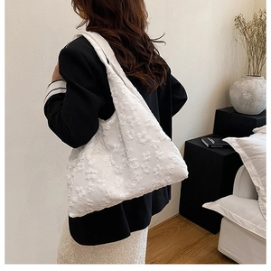 Close-up of white floral jacquard texture and 3D embossed pattern on large tote bag