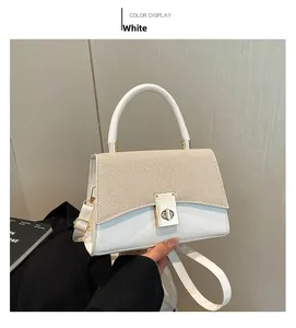 Detail of white textured flap bag with a golden twist lock and elegant top handle