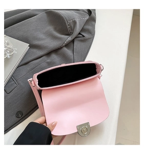 Detail view of pink crossbody bag interior with silver metal lock and black lining