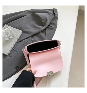 Detail view of the pink leather crossbody bag interior with silver cylindrical twist lock
