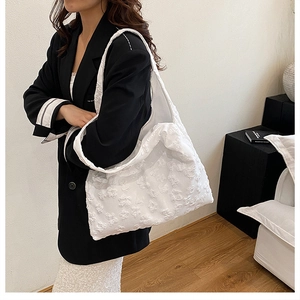 Detail of white 3D floral relief texture on aesthetic lace shoulder tote bag
