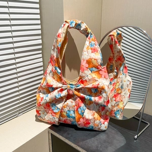Floral canvas shoulder bag with large bow decoration and colorful botanical prints