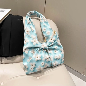 Light blue floral hobo shoulder bag with a large bow design and white flower patterns