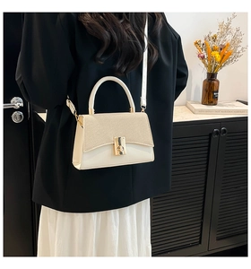 Detail of cream white crossbody bag with woven texture lid and metal square lock