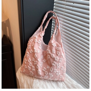 Close-up of pink tote bag featuring 3D white floral lace texture and matching handle