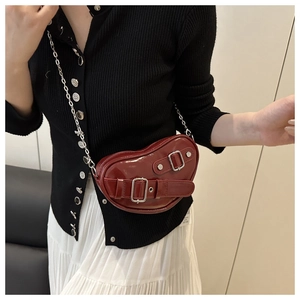 Détail du sac coeur en cuir verni rouge foncé avec bandoulière chaîne argentée