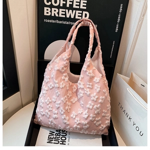 Detail of pink fabric tote bag with 3D white flower embroidery and rich texture