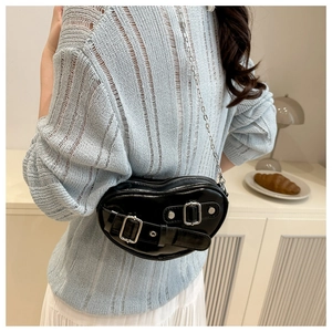 Détail du sac cœur noir avec boucles argentées et bandoulière en chaîne métallique