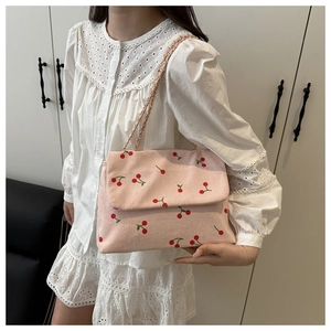 Détail du sac cabas en velours côtelé rose avec motif cerises et bandoulière chaîne