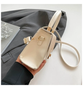 Detail of cream leather and woven texture crossbody bag with elegant gold hardware