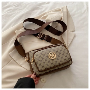 Detail of vintage monogram crossbody bag with wide strap and golden M metal logo