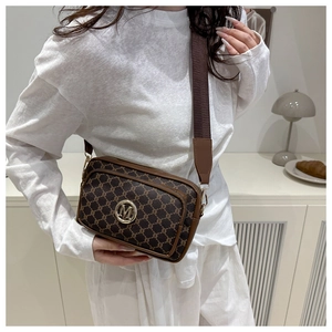 Retro brown crossbody camera bag with vintage pattern and adjustable strap worn by model