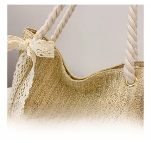 Detail of straw woven bag with lace bow, cotton rope handle and metal eyelets
