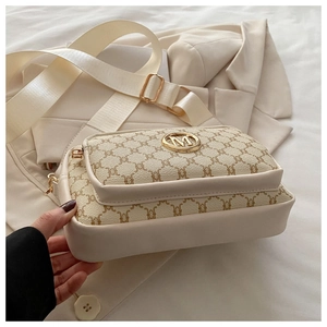 Detailed macro view of the beige crossbody bag with vintage monogram and gold M hardware