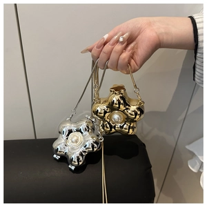 Macro shot of gold and silver star-shaped mini bags with large pearl details and snake chains