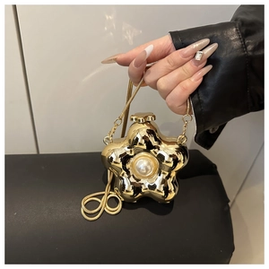 Detailed macro view of a gold flower evening bag with a large central pearl and chain strap