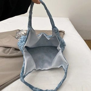 Light blue floral lace tote bag showing a spacious interior and textured 3D flower pattern