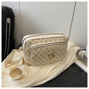 Detail view of vintage cream crossbody bag with brown monogram pattern and golden hardware