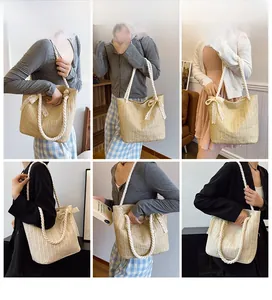 Detail of hand-woven straw tote with thick rope handles and decorative lace bow accents