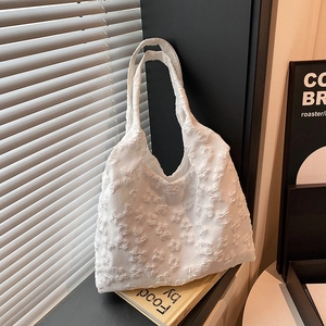 Elegant white floral lace tote bag for women with 3D texture on minimalist display