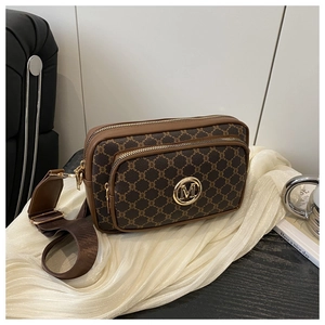 Detail of vintage logo pattern camera bag with gold M logo and double zip hardware