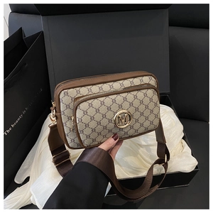 Detail of vintage monogram crossbody bag with gold M logo in premium gift packaging