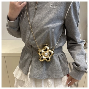 Detailed view of a mini gold flower crossbody bag with a large central pearl and chain strap