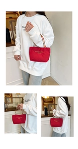 Detail of red canvas mini tote bag with colorful beaded handle and gold lettering