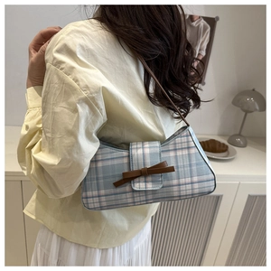 Detail of vintage plaid underarm bag with leather bow and adjustable shoulder strap