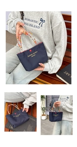 Close-up of navy nylon tote bag featuring a colorful beaded handle and gold lettering